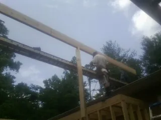 Carpenter setting a ridge beam over a new addition frame — Ice Dam Removal by Roofing Brothers in Great Lakes