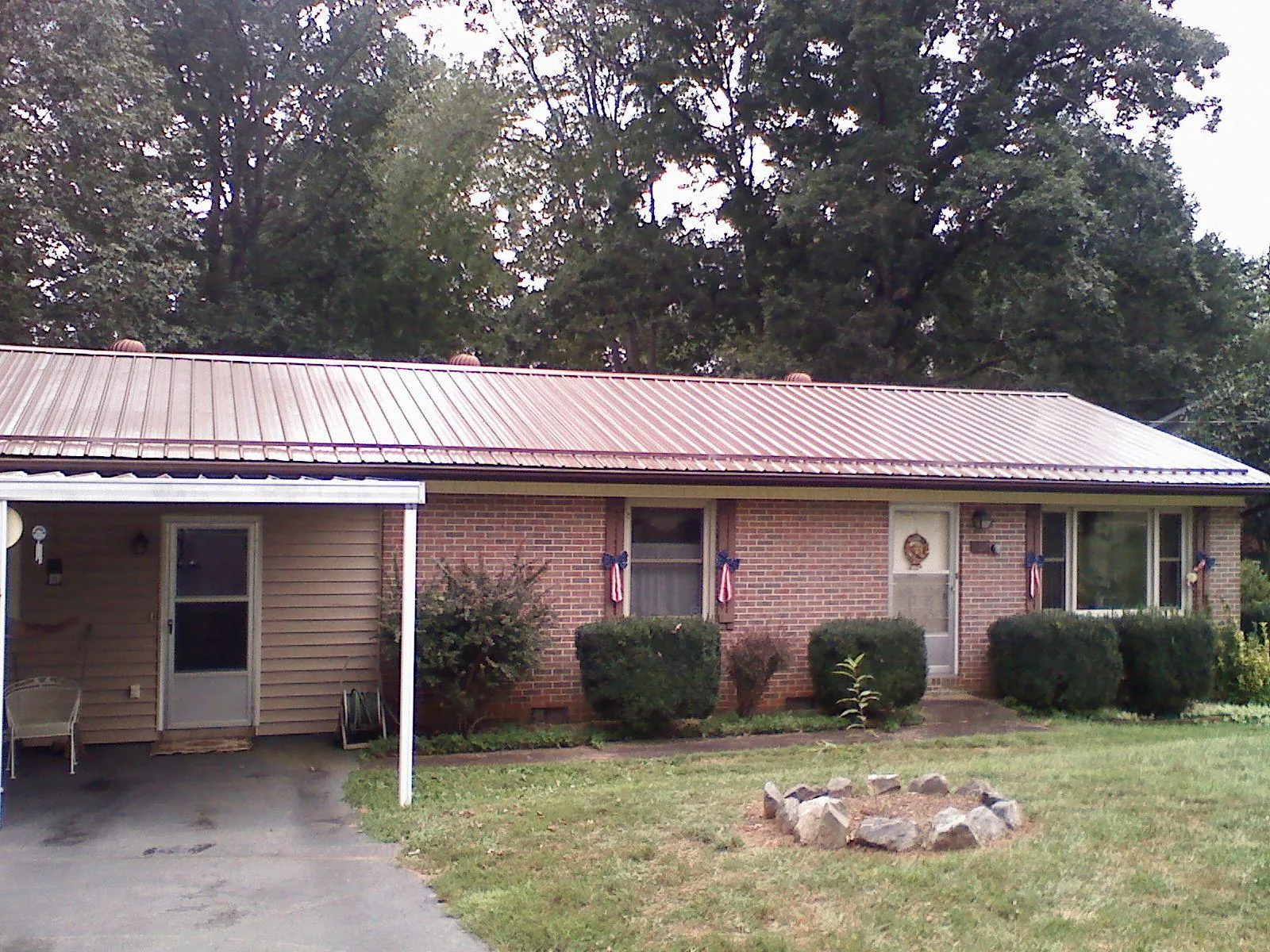 Bronze metal roof and carport on a brick ranch home — Roof Repair work by our crew in Great Lakes