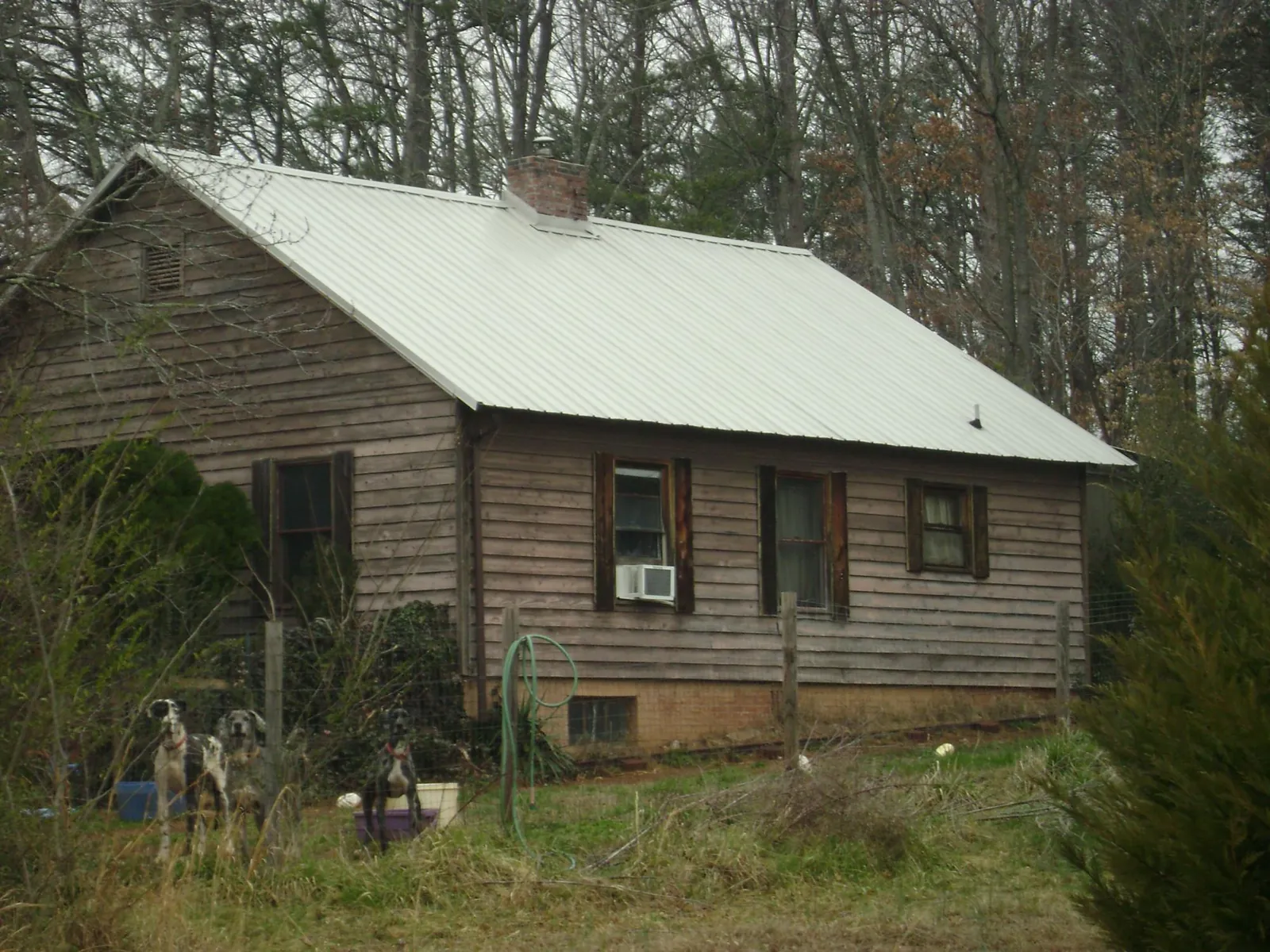 White metal roof on an old wood sided farmhouse, from a Metal Roof Installation job in Great Lakes